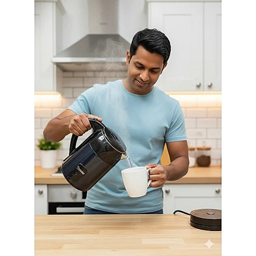 Man pouring tea from a black kettle into a white mug in a kitchen.