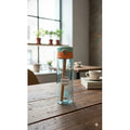 Clear water bottle with green cap on a wooden table