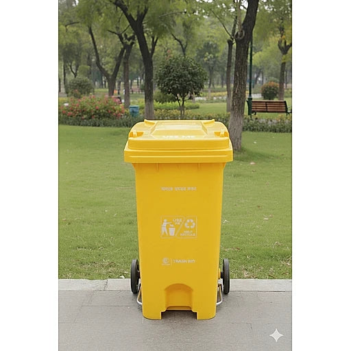 Yellow trash bin with recycling symbols in a park setting
