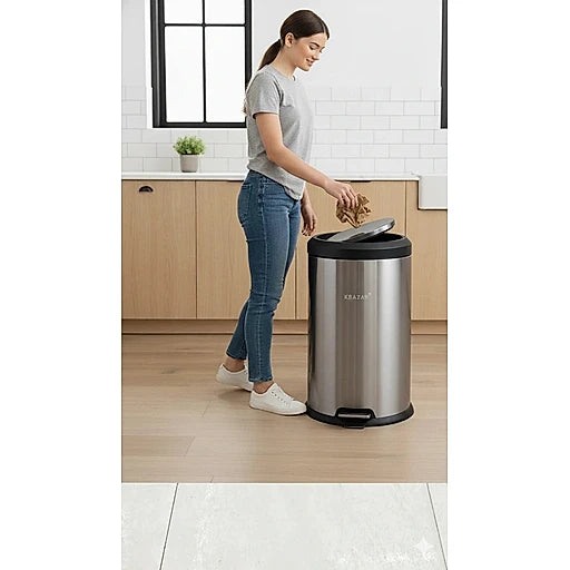 Woman disposing of trash into a stainless steel trash can in a kitchen.