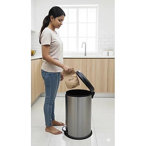 Woman disposing of trash into a kitchen trash can.