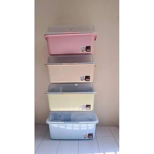 Stack of four pastel-colored storage bins with lids on a light-colored floor.